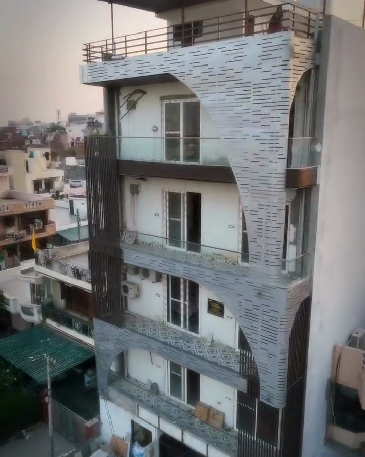 A completed Dream BuildTech builder floor — four storeys with perforated stone cladding and tiled balconies